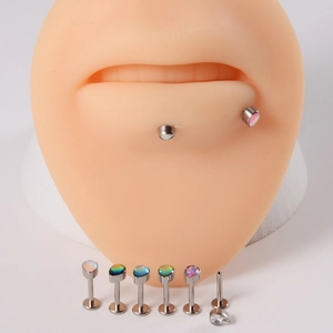 Détail macro de piercings labret en titane G23 avec incrustations d'opale et de zircon