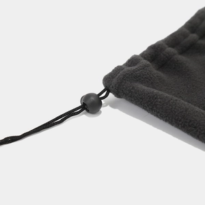 Detail of black polar fleece beanie with adjustable drawstring and toggle closure