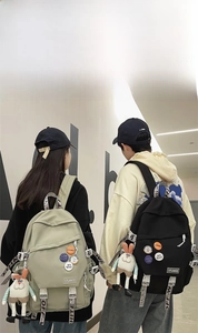 Detail of durable canvas backpacks in khaki and black with trendy decorative patches