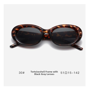 Detail view of tortoiseshell oval sunglasses with dark gray lenses and size specs