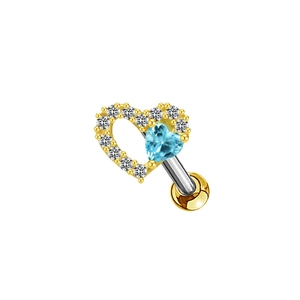 Détail d'un bijou de piercing en cœur avec pierre bleue et design à vis de fixation