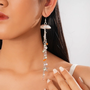 Macro detail of jellyfish earrings with colorful beads and star charms on model