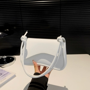 Minimalist white shoulder bag with unique wave flap and knotted strap detail