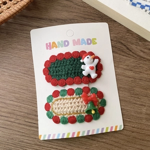 Detailansicht der handgestrickten Weihnachtshaarspangen mit Schneemann- und Schleifenmotiv