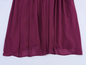 Détail de l'ourlet à volants violet sur une robe à manches longues en tissu fluide
