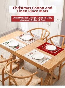 Close-up of linen blend Christmas placemats with Santa patterns on a rustic wooden table