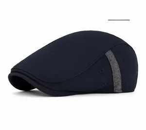 Detail of navy blue flat cap featuring side grey stripe and metal ventilation eyelets