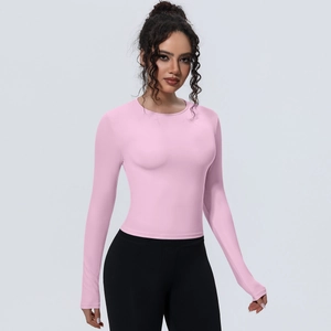 Vue détaillée du haut de yoga rose à manches longues et coupe ajustée en tissu respirant