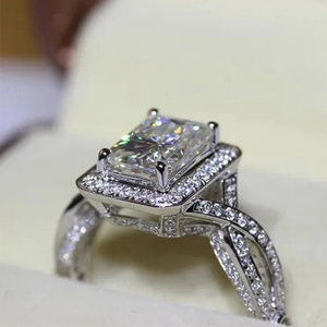 Elegante anillo de compromiso con halo rectangular y banda retorcida de circonita