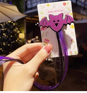 Detail of purple sequin bat hair clip with long black and purple synthetic hair extensions