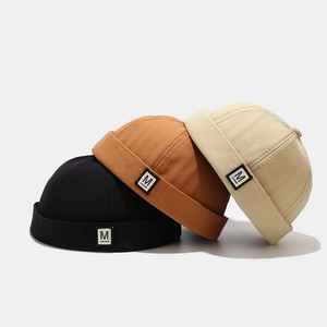 Cotton docker hats in black, caramel, and beige featuring a minimalist M fashion label