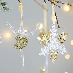 Elegant acrylic Christmas snowflake and ballerina ornaments with gold glitter on pine branch