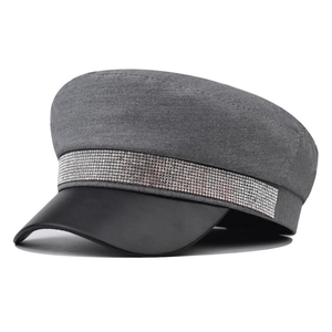 Detail of grey baker boy hat with sparkling rhinestone trim and black leather visor