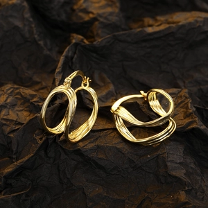 Elegante goldene mehrlagige Wellen-Ohrringe auf schwarzem Hintergrund
