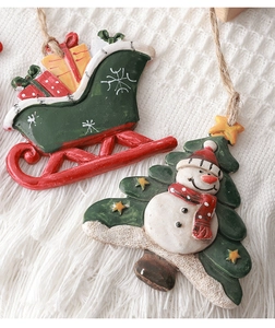Detailed macro view of resin Christmas sleigh and snowman ornaments on white knit blanket