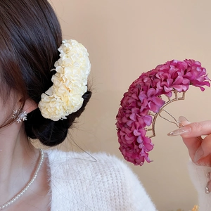 Detailed close-up of handmade fabric flower hair pins in cream and purple colors