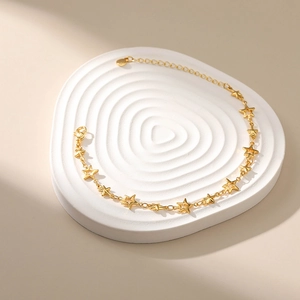 Star charm bracelet in 18k gold plated finish with solid and hollow star pendants