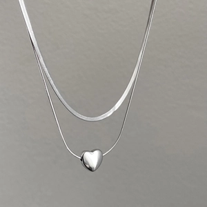 Minimalist silver double-layered necklace featuring flat snake chain and heart pendant