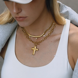 Collares dorados en capas con colgante de cruz y circonitas en una cadena con cierre T