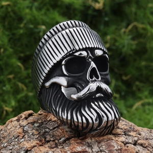 Macro detail of retro skull ring with mustache and beanie on natural wood bark
