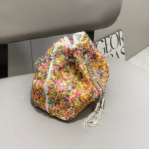 Macro detail of luxury colorful rhinestone bucket bag with crystal fringe and silver chain