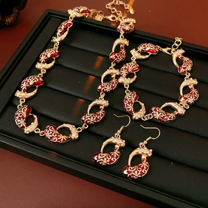 Detailed shot of vintage gold jewelry set with red enamel paisley and zircon accents