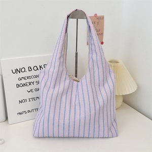 Detail of colorful striped canvas tote bag showing textile texture and handle design