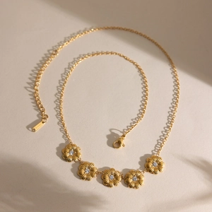 Détail du collier marguerite 18K montrant le poinçon S-STEEL et les zircons blancs