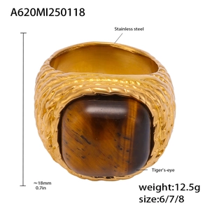 Macro view of wide stainless steel ring featuring tiger's eye stone and woven texture