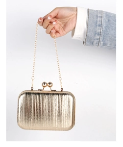 Detailed close-up of golden metallic clutch bag with vertical pleated texture and ball clasp