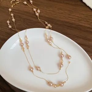 Collier long style français avec perles roses et cristaux sur chaîne dorée élégante