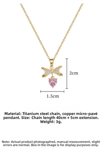 Detail of gold titanium steel necklace with pink heart pendant and bowknot inlay details