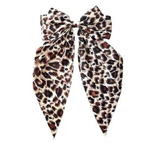 Large leopard print bow hair clip with long streamers on a clean white background