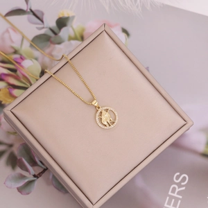 Macro shot of 18K gold constellation pendant with micro-pave crystals on box chain