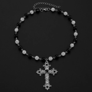 Vue macro du pendentif croix gothique avec pierre noire et détails filigranés