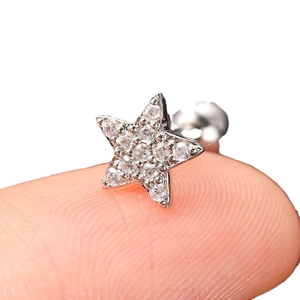 Silver star screw back stud earring with white zircons shown on finger for scale