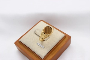 Close-up of gold signet ring with round tiger eye stone on a jewelry display stand