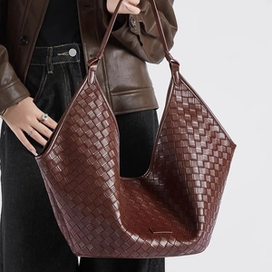 Detail der dunkelbraunen geflochtenen Ledertasche mit feiner Intrecciato-Handwerkskunst