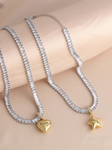 Detailed view of 18k gold heart and star pendants with pavé crystals on a stylish chain