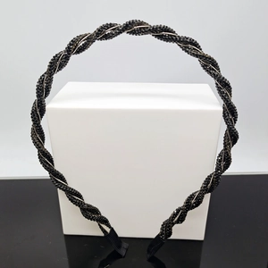Close-up of a delicate black beaded woven headband with fabric wrapped protective ends