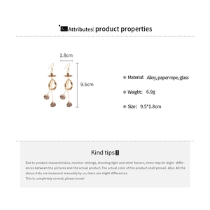 Detail view of wood and glass bead drop earrings with paper rope and golden hook