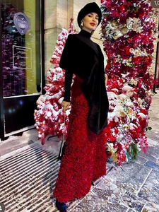 Detail of red long skirt with 3D floral texture paired with black winter accessories