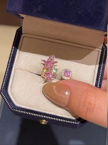 Detail of adjustable gold ring with pink star gemstone and colorful zircon accents