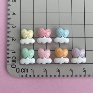 Macro view of mini resin heart cloud charms with scale ruler for size measurement