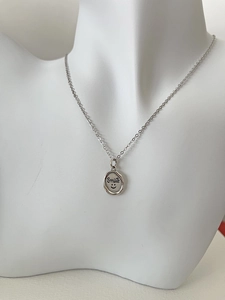 Detailed view of 925 sterling silver smile pendant on a necklace displayed on a mannequin