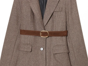 Detailed view of brown herringbone wool blazer with textured belt and gold buckle