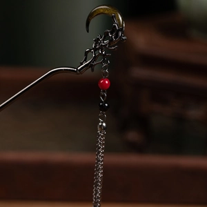 Macro shot of an antique dragon hair pin with flowing tassels and dark metal texture