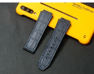 Detailed view of dark blue crocodile embossed leather strap with navy blue stitching