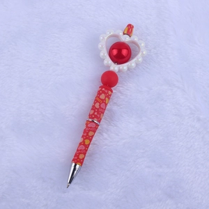 Detail of red Valentine silicone bead pen with white pearl heart and LOVE text pattern