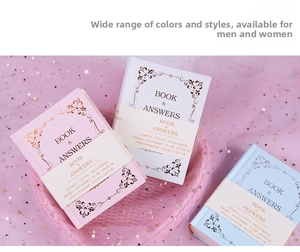 Three bilingual Book of Answers notebooks in pink, white, and blue on mesh star fabric